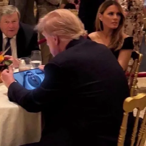 Трамп показывает что-то на планшете