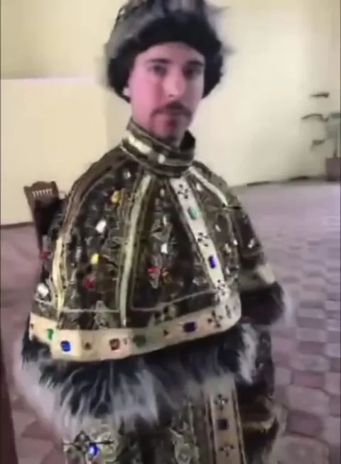 Человек в царском наряде у бассейна