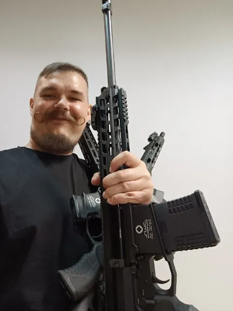 Довольный парень с винтовками