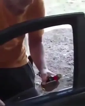 Мужчина у машины с бутылкой