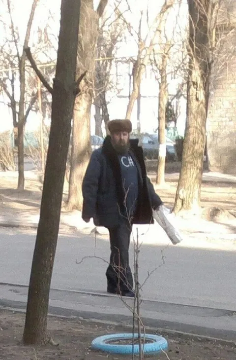 Мужчина с пакетом у дерева