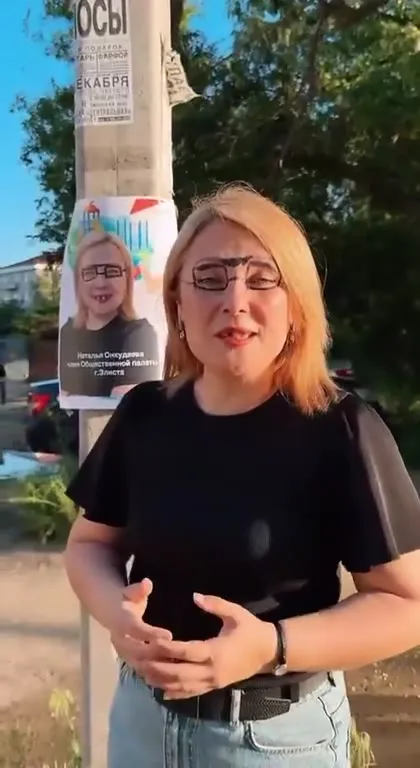 Женщина рядом со своим плакатом