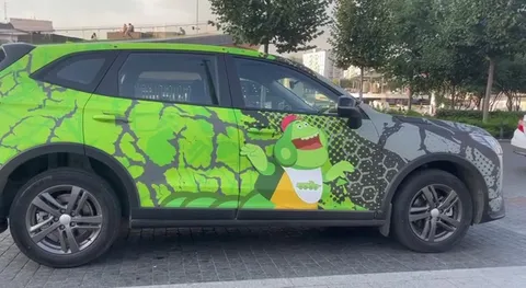 Машина с зелёным динозавром