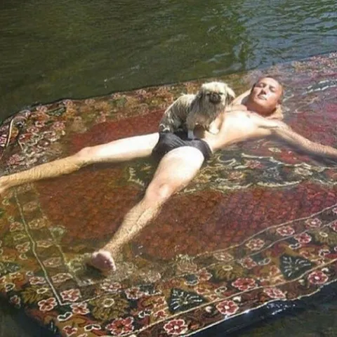 Мужчина и собака на ковре