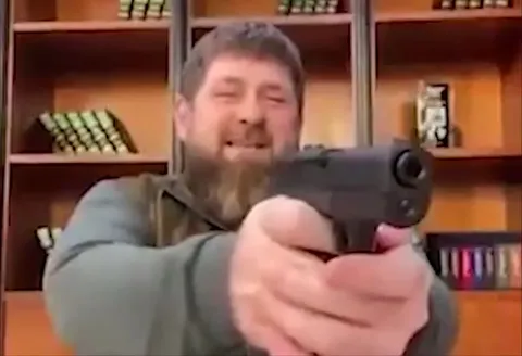 Бородатый мужчина целится в камеру