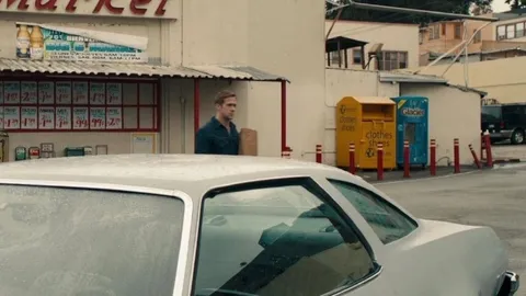 Ryan Gosling Walking Behind a Car