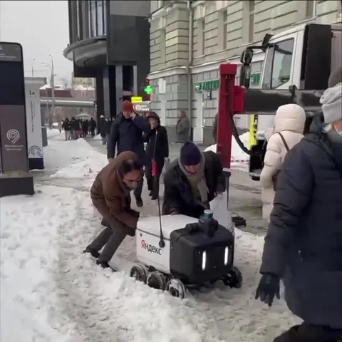 Люди спасают робота из снега
