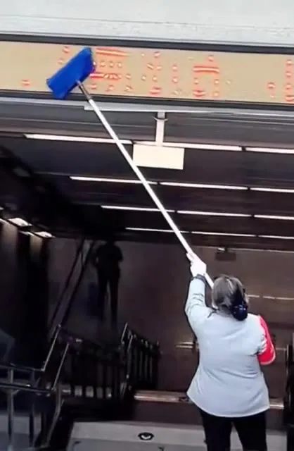 Мытьё вывески длинной шваброй