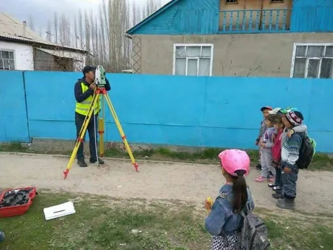 Дети наблюдают за геодезистом