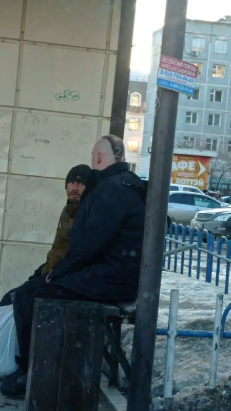 Мужчина сидит на урне