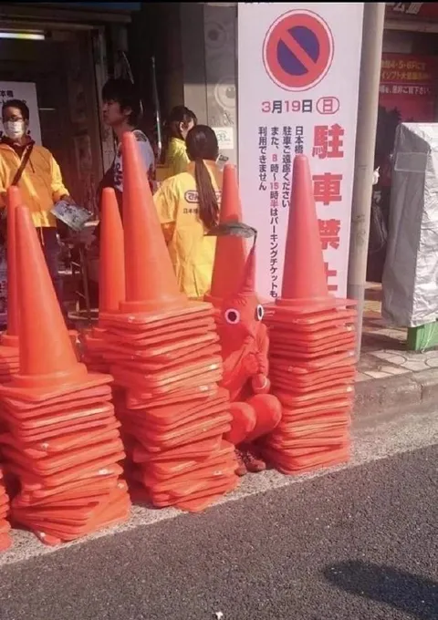 カラーコーンに隠れる人
