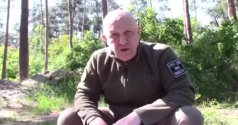 Лысый мужчина объясняет в лесу