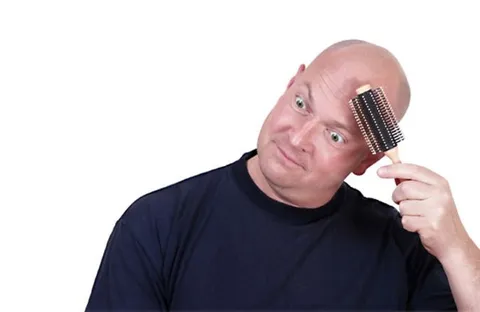 Лысый мужчина расчёсывает голову