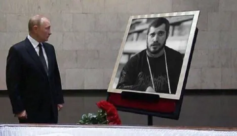 Путин смотрит на портрет