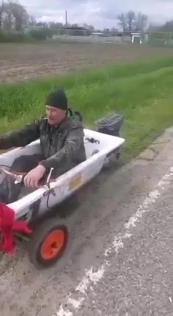 Мужик вылезает из лодки на колёсах