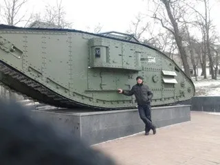 Мужчина показывает на танк