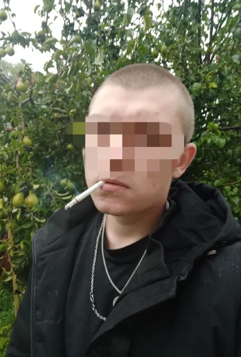 Парень с сигаретой в саду