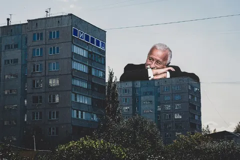 Мужчина выглядывает из-за дома