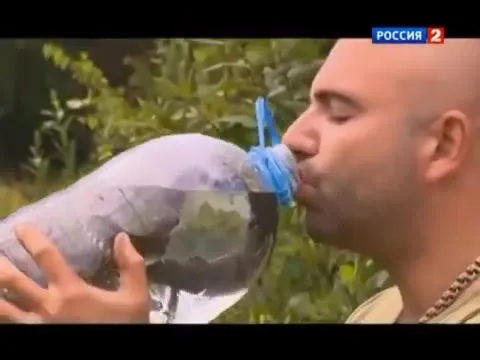 Мужчина пьёт из огромной бутылки