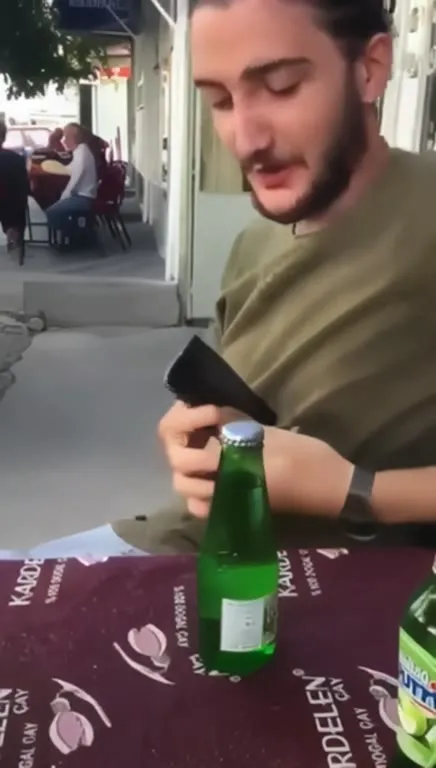 Şişeyi açmaya çalışan adam
