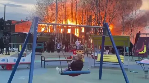 Качели на фоне пожара