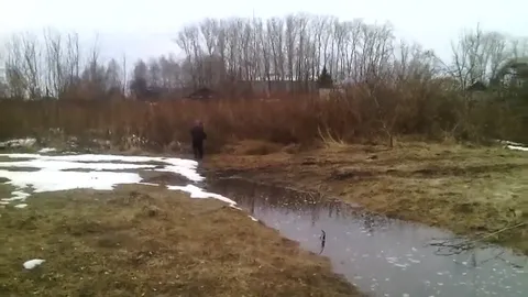 Мужчина нелепо переходит ручей