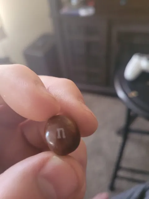 Коричневый M&M’s с буквой П