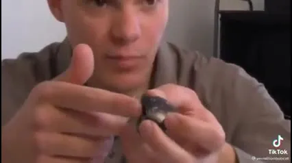 Man Puts Black Object on Nose