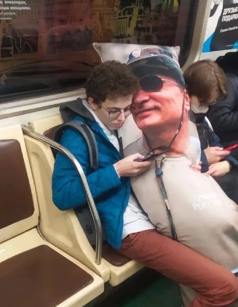 Обнимает подушку с лицом