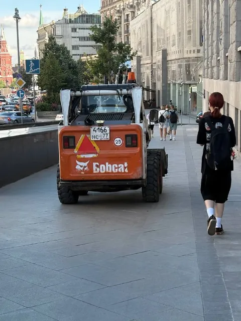 Bobcat работает на тротуаре