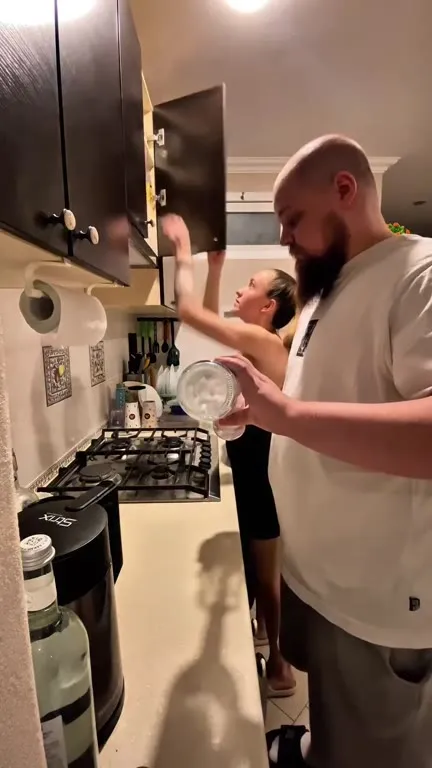 Мужчина выпивает на кухне