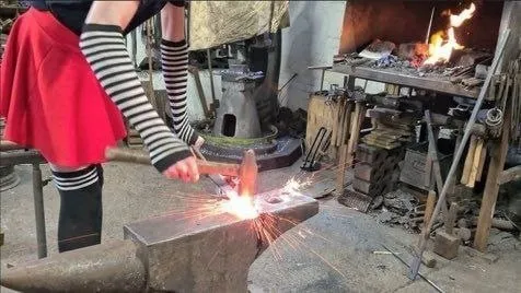 Девушка кует железо