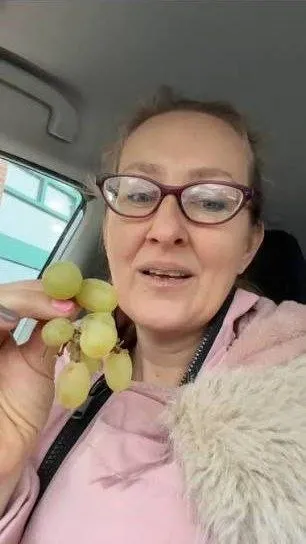 Женщина с виноградом в машине