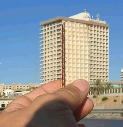 Пальцами держит здание
