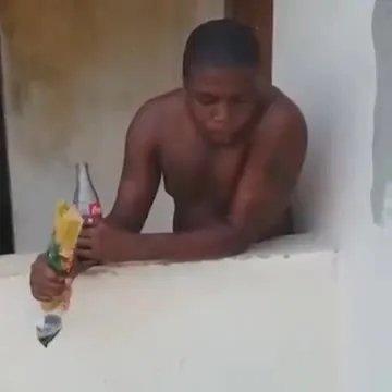 Мужчина задумчиво пьёт у стены