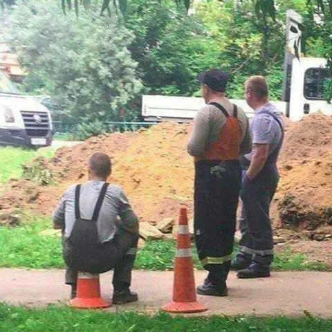 Рабочий сидит на конусе