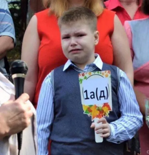 Плачущий мальчик с табличкой