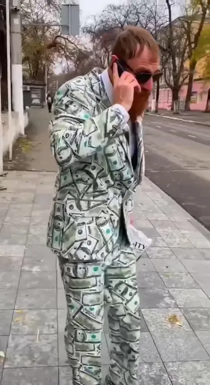 Мужчина в костюме из денег спешит в столовую