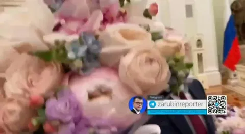 Путин с букетом закрывает камеру