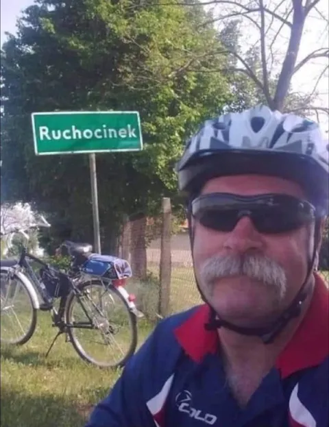 Rowerzysta przy znaku Ruchocinek