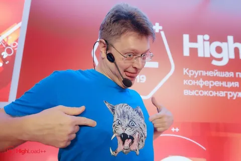 Мужчина показывает кричащего кота на футболке