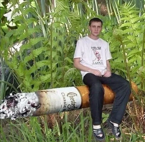 Man Sitting on a Giant Cigarette