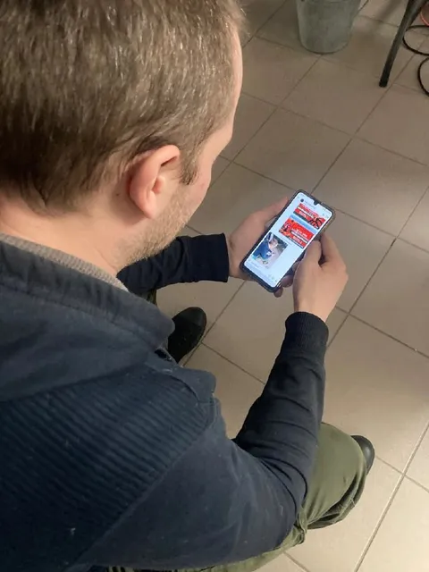 Мужчина читает мем в телефоне