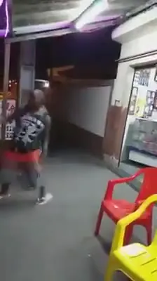 Двое мужчин танцуют у магазина