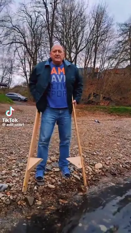 Мужчина переходит ручей на ходулях