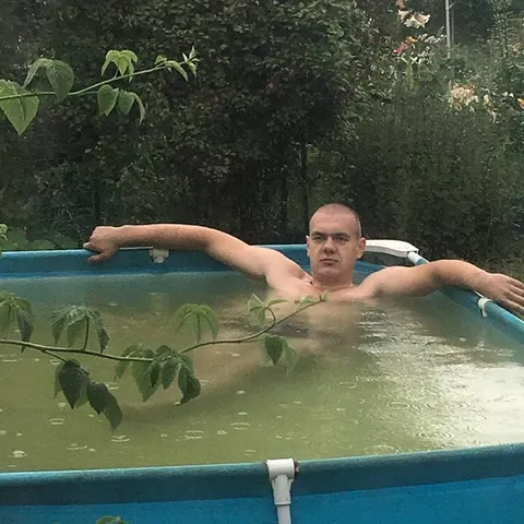 Мужчина расслабляется в бассейне
