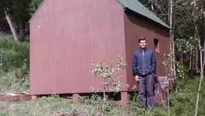 Мужчина у лесного сарая