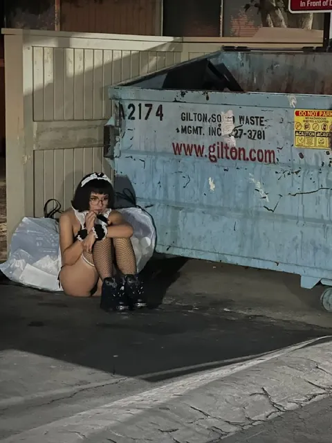 Girl Hiding Beside Dumpster