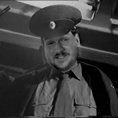 Суровый военный смотрит в камеру