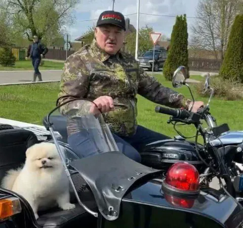 Суровый байкер с пушистой собакой
